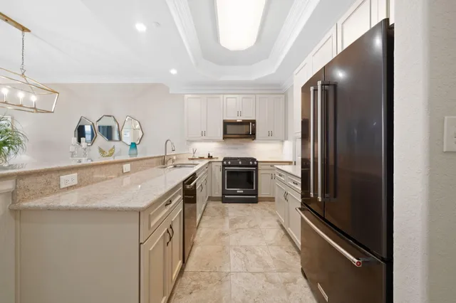 a kitchen with a sink stainless steel appliances a counter top space and cabinets