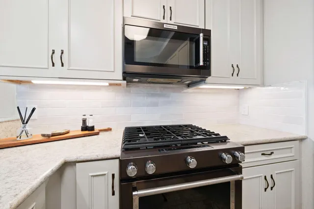 a kitchen with granite countertop cabinets stainless steel appliances and wooden floor