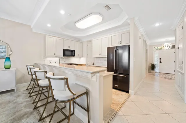 a kitchen with stainless steel appliances a refrigerator stove microwave and white cabinets