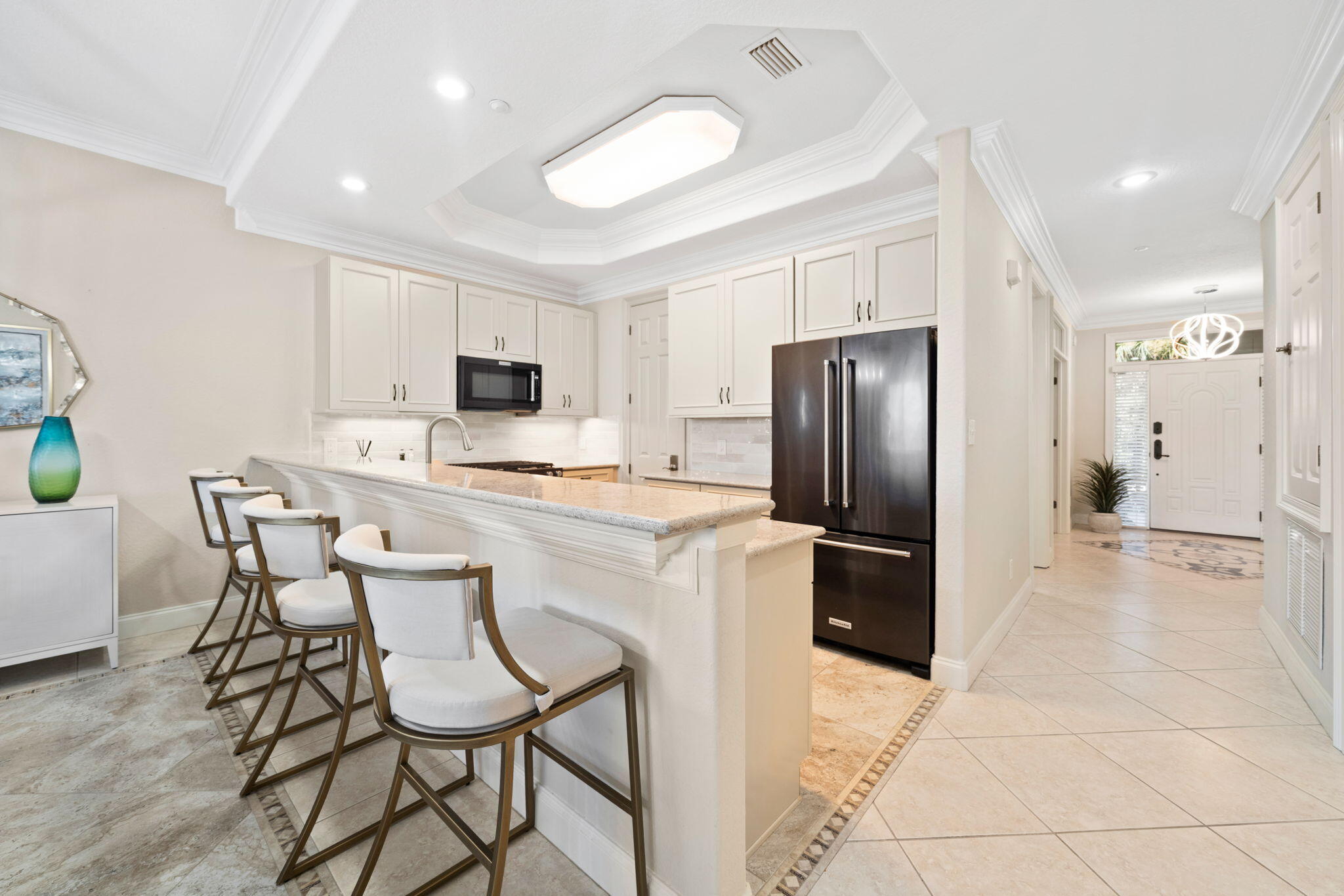 602 Harbor Boulevard, Unit 103 Destin, FL 32541 - Photo 19 of 47 a kitchen with stainless steel appliances a refrigerator stove microwave and white cabinets