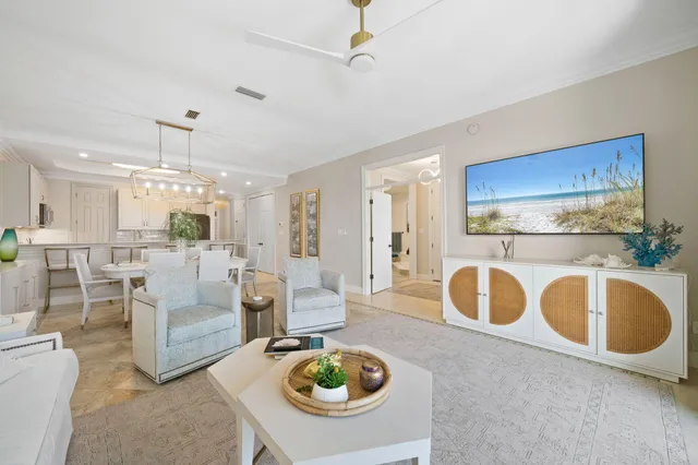 a living room with furniture a rug and white stainless steel appliances