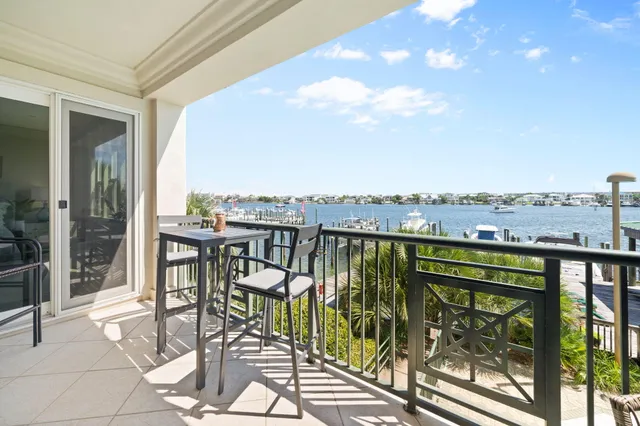 a view of swimming pool from a balcony with furniture