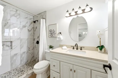 a bathroom with a sink a toilet and a mirror