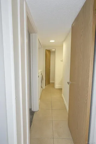 a view of a hallway with wooden floor and a bathroom