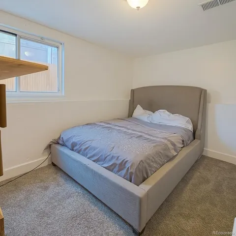 a large bed sitting in a bedroom next to a window