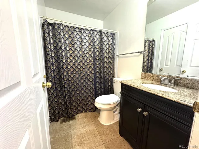 a bathroom with a granite countertop sink toilet and a mirror