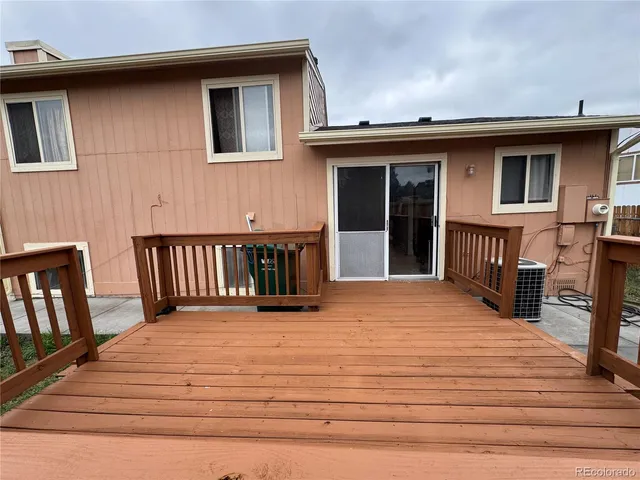 a view of a house with wooden deck and furniture