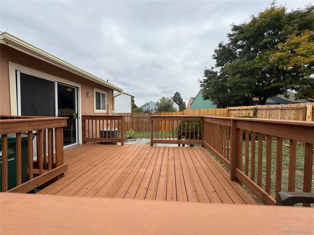a balcony with wooden floor and fence