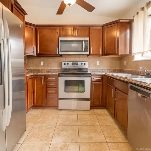 a kitchen with stainless steel appliances granite countertop a stove top oven microwave and cabinets