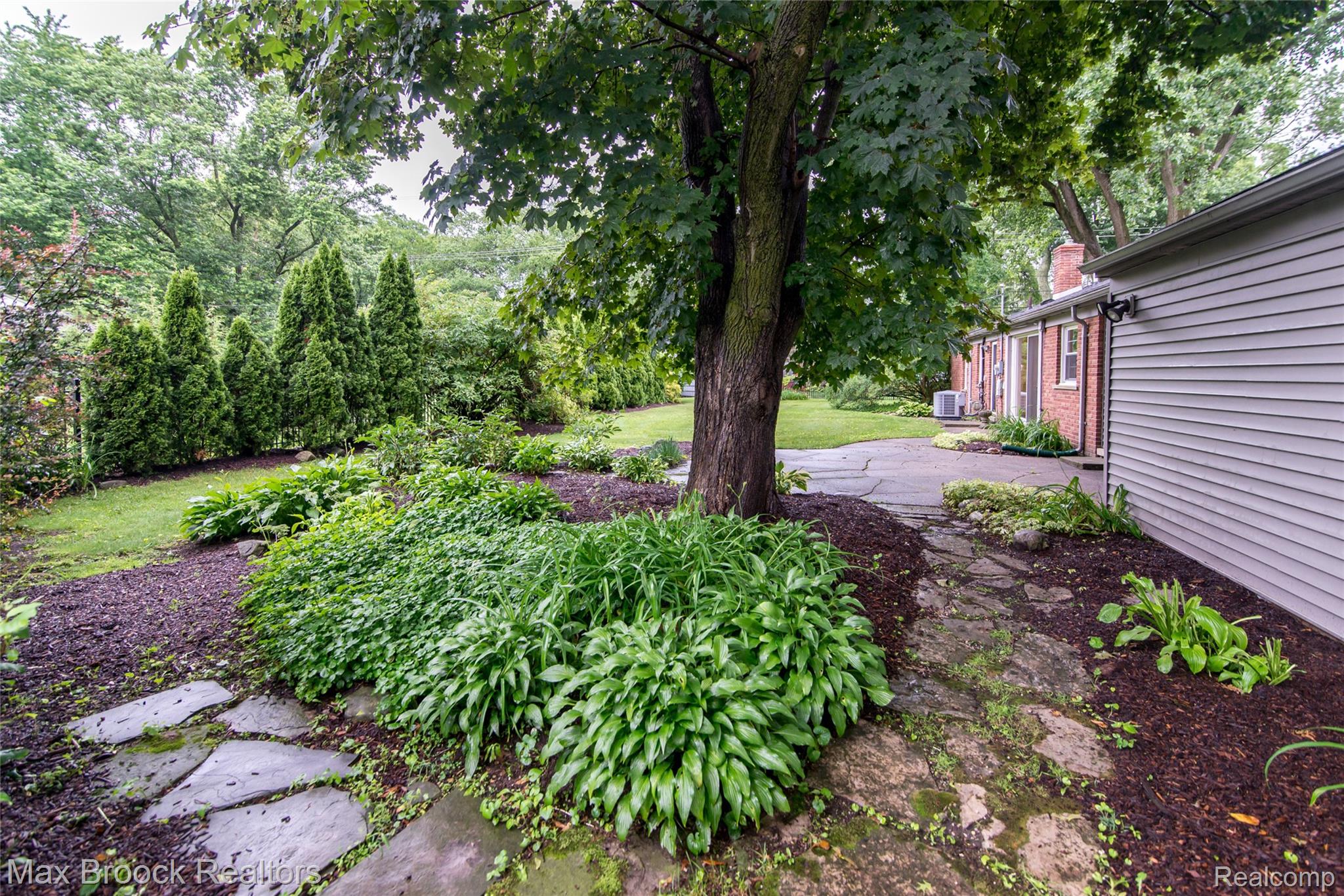 6799 East Dartmoor Road West Bloomfield, MI 48322 - Photo 30 of 36 Expansive rear yard featuring mature trees, established plantings, and a flagstone path