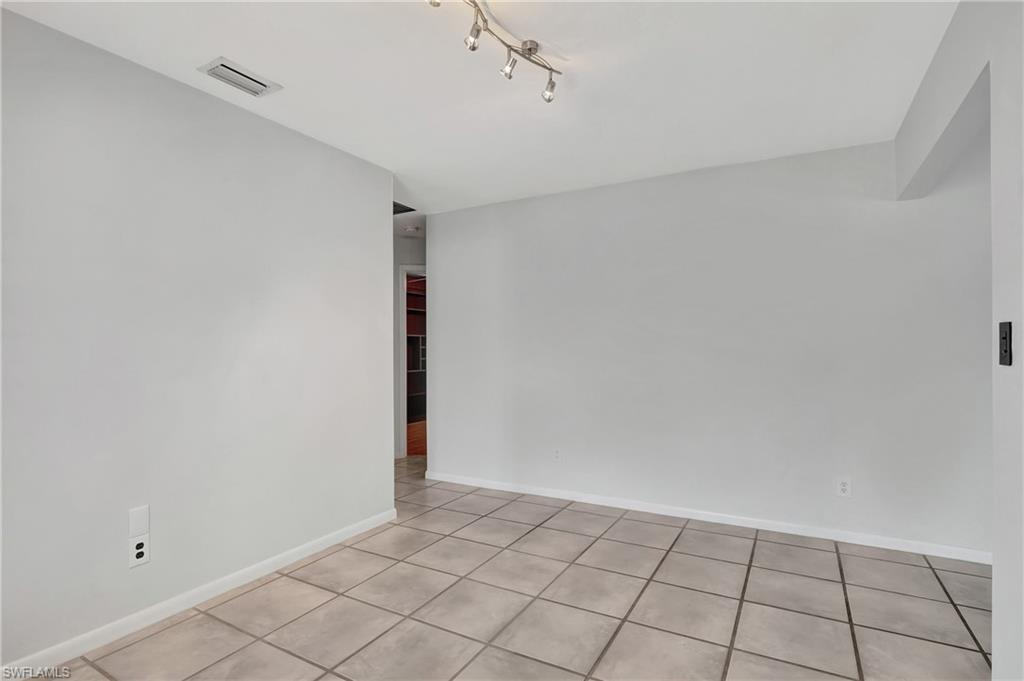 3035 42nd Terrace Southwest Naples, FL 34116 - Photo 14 of 48 Formal dinning room featuring light tile patterned floors and rail lighting.