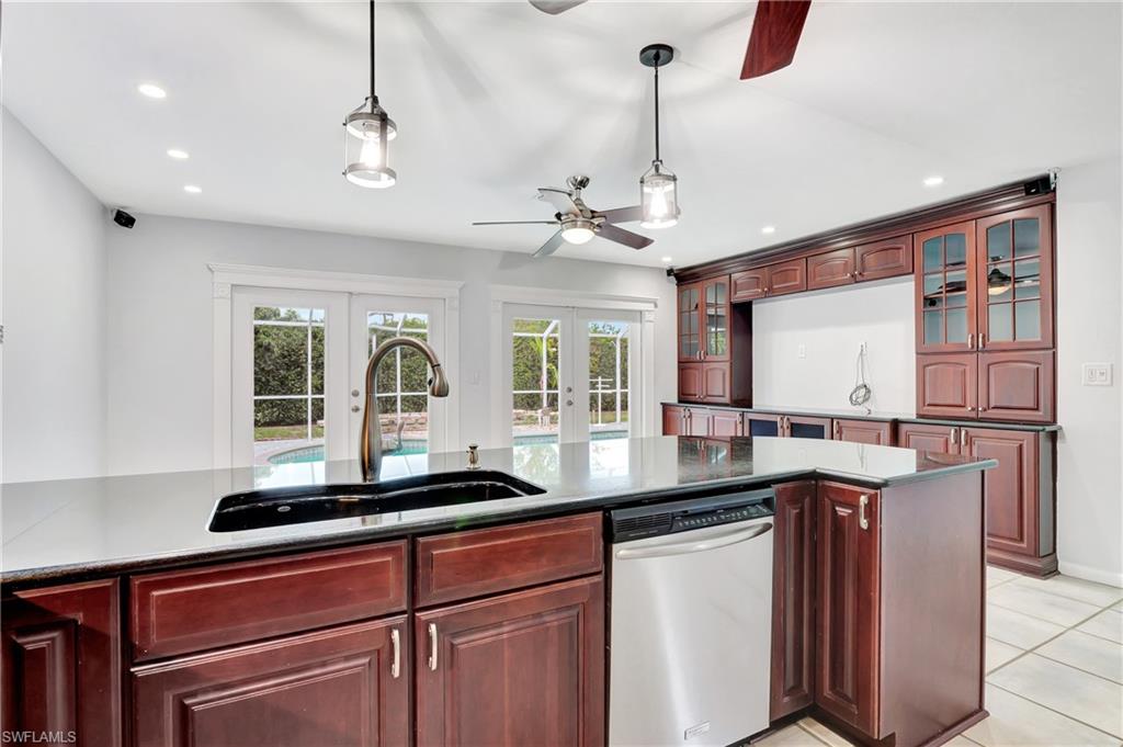 3035 42nd Terrace Southwest Naples, FL 34116 - Photo 20 of 48 Kitchen featuring french doors, dishwasher, hanging light fixtures, glass insert cabinets, and wood finish cabinets