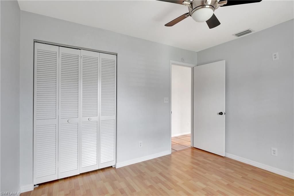 3035 42nd Terrace Southwest Naples, FL 34116 - Photo 24 of 48 Unfurnished bedroom featuring a ceiling fan, light wood finished floors, and a closet.