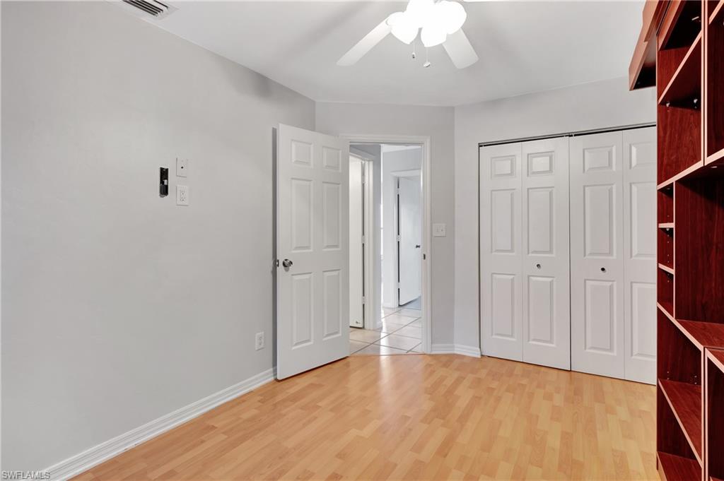 3035 42nd Terrace Southwest Naples, FL 34116 - Photo 29 of 48 2nd guest room featuring ceiling fan and light wood-type flooring bedroom with light wood-style flooring, a ceiling fan, and a closet