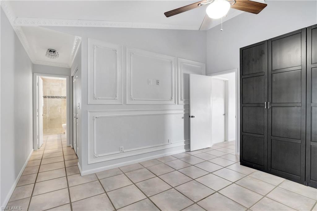 3035 42nd Terrace Southwest Naples, FL 34116 - Photo 38 of 48 Master bedroom featuring light tile patterned flooring, lofted ceiling, and a ceiling fan