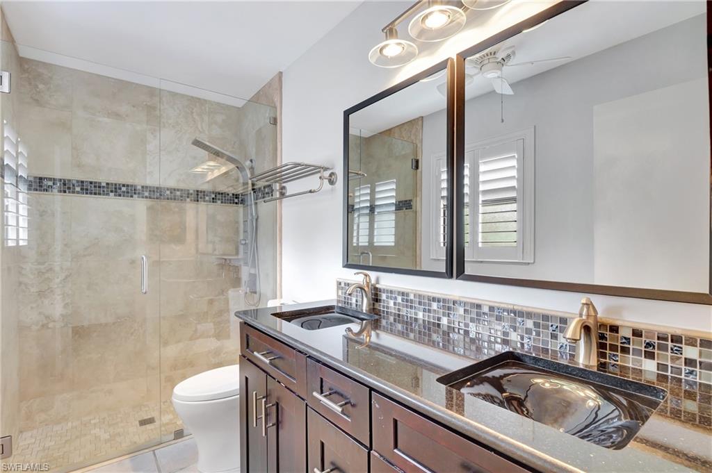 3035 42nd Terrace Southwest Naples, FL 34116 - Photo 40 of 48 Master Bathroom with double vanity, a stall shower, light tile patterned floors, and a ceiling fan