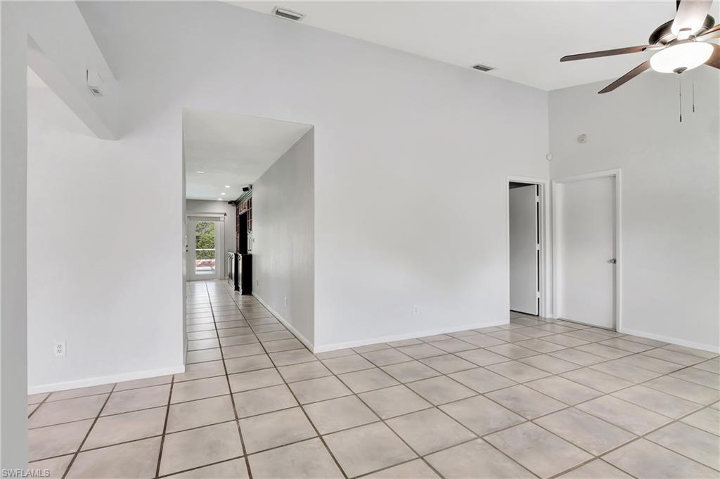 3035 42nd Terrace Southwest Naples, FL 34116 - Photo 10 of 48 Living room with ceiling fan, light tile patterned floors, and a high ceiling.