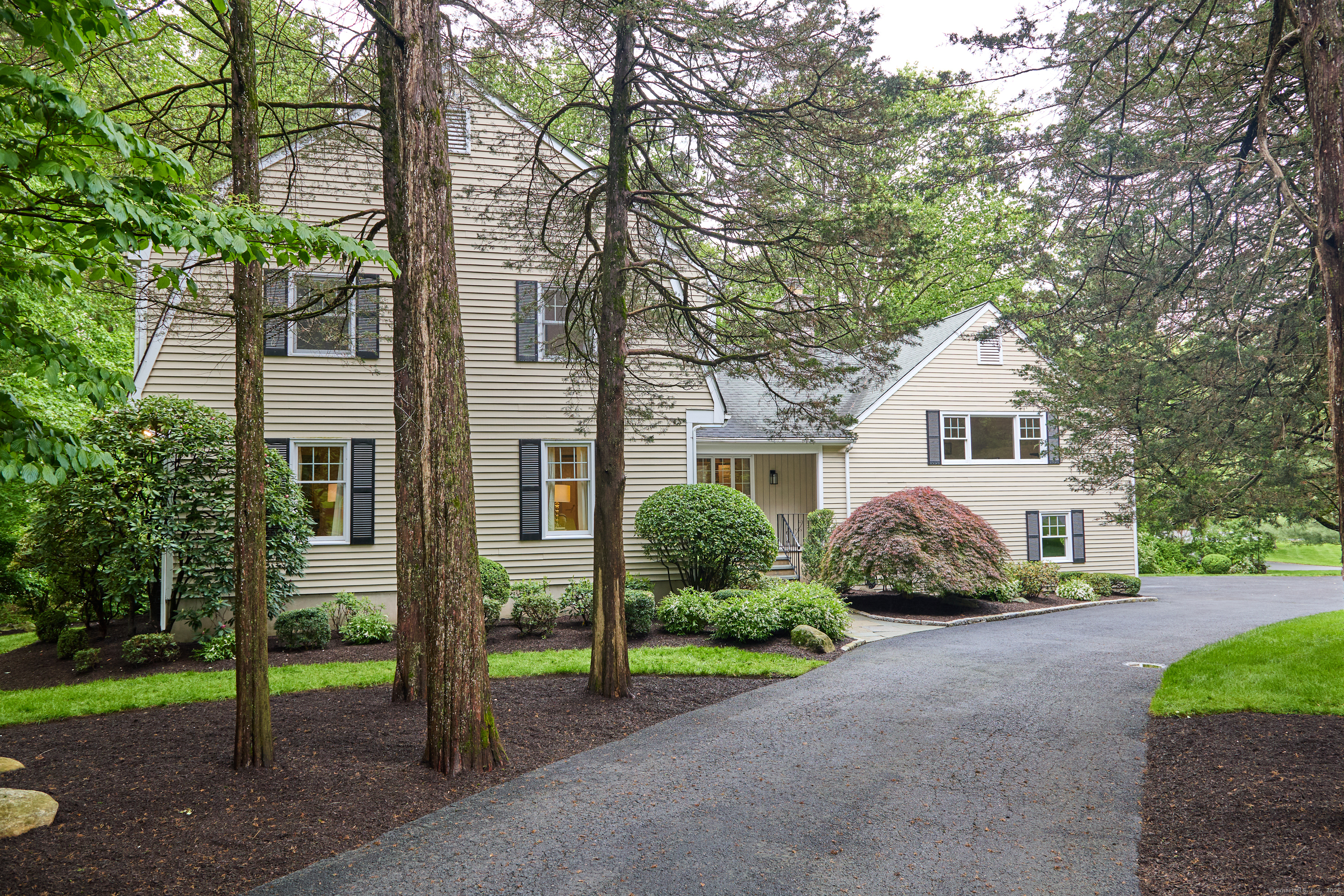 42 Trails End Road Weston, CT 06883 - Photo 1 of 1 a front view of a house with a garden and trees