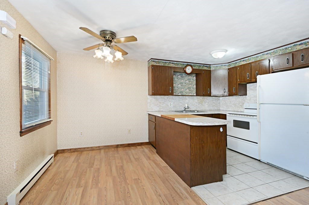 2240-2242 Barre Road Hardwick, MA 01031 - Photo 15 of 31 a kitchen with granite countertop a refrigerator a sink dishwasher and wooden cabinets with wooden floor