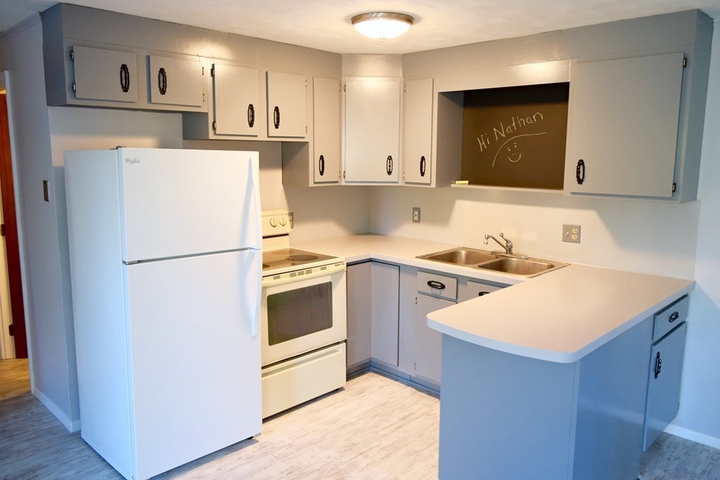 2240-2242 Barre Road Hardwick, MA 01031 - Photo 26 of 31 a kitchen with a refrigerator a stove top oven and white cabinets