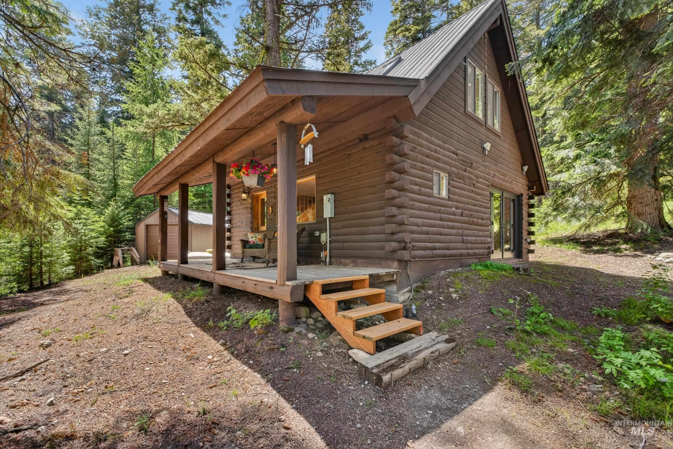 2339 West Mountain Road Donnelly, ID 83615 - Photo 29 of 37 Log cabin exterior featuring a covered porch, wood stairs, and a metal roof
