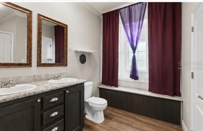 8010 Palmer Road Bartow, FL 33830 - Photo 15 of 22 a bathroom with a toilet a sink a mirror and a window