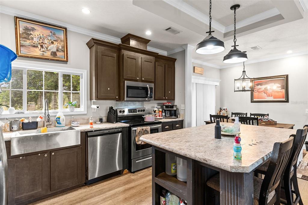 8010 Palmer Road Bartow, FL 33830 - Photo 10 of 22 a kitchen with granite countertop a stove a sink a dining table and chairs
