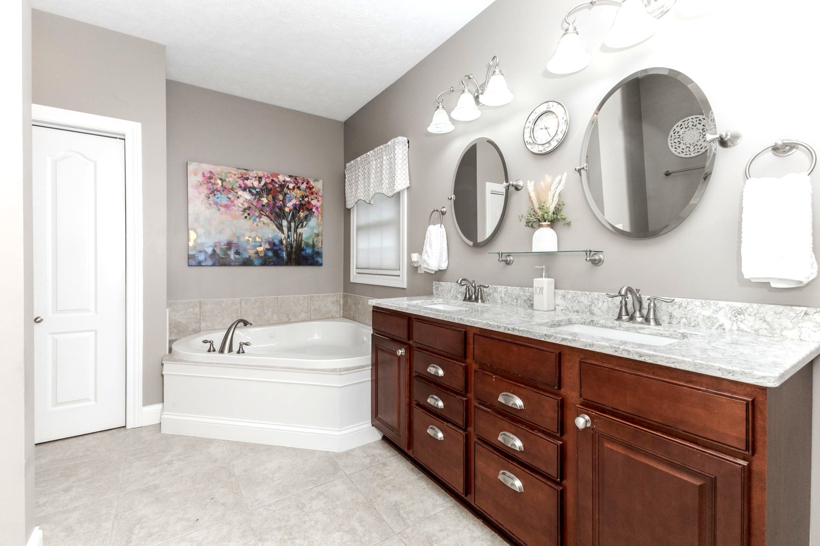36 Lone Oak Court Bloomington, IL 61705 - Photo 23 of 63 a bathroom with a tub a double vanity sink and a mirror