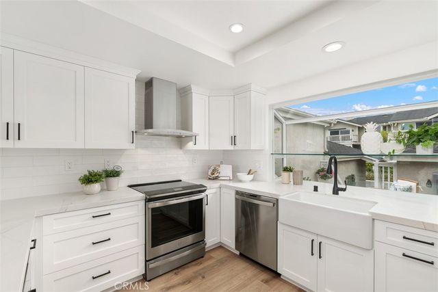a kitchen with white cabinets stainless steel appliances and sink