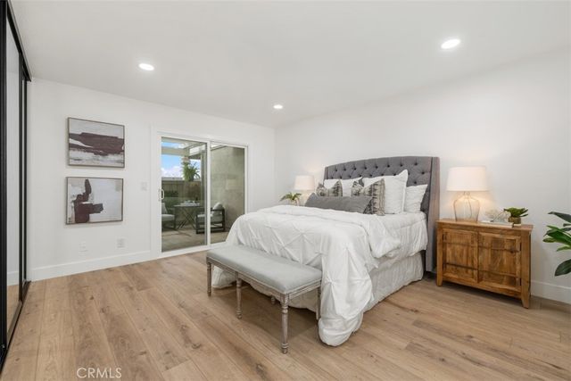 a bed sitting in a spacious bedroom next to a window