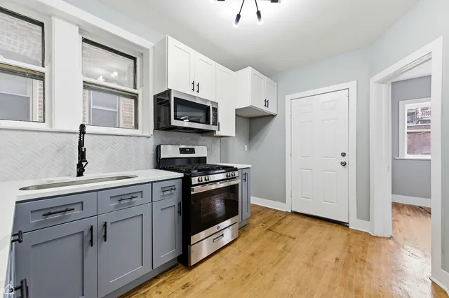 a kitchen with stainless steel appliances granite countertop a stove a sink and a microwave