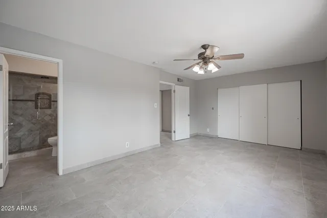 a view of an empty room with a ceiling fan