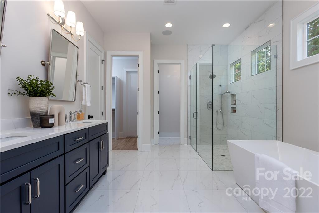 7209 Ramsgate Road Charlotte, NC 28270 - Photo 26 of 41 a bathroom with a double vanity sink a large mirror a shower and bathtub
