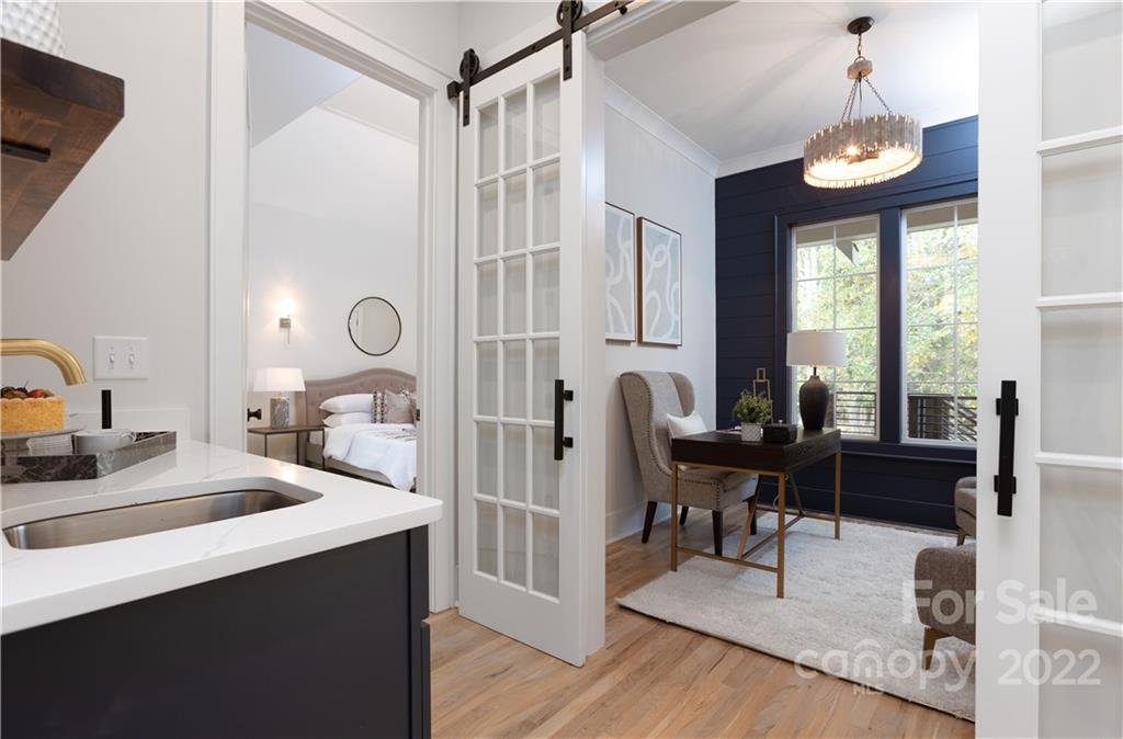 7209 Ramsgate Road Charlotte, NC 28270 - Photo 30 of 41 a view of a hallway with a dining table chairs a chandelier and wooden floor