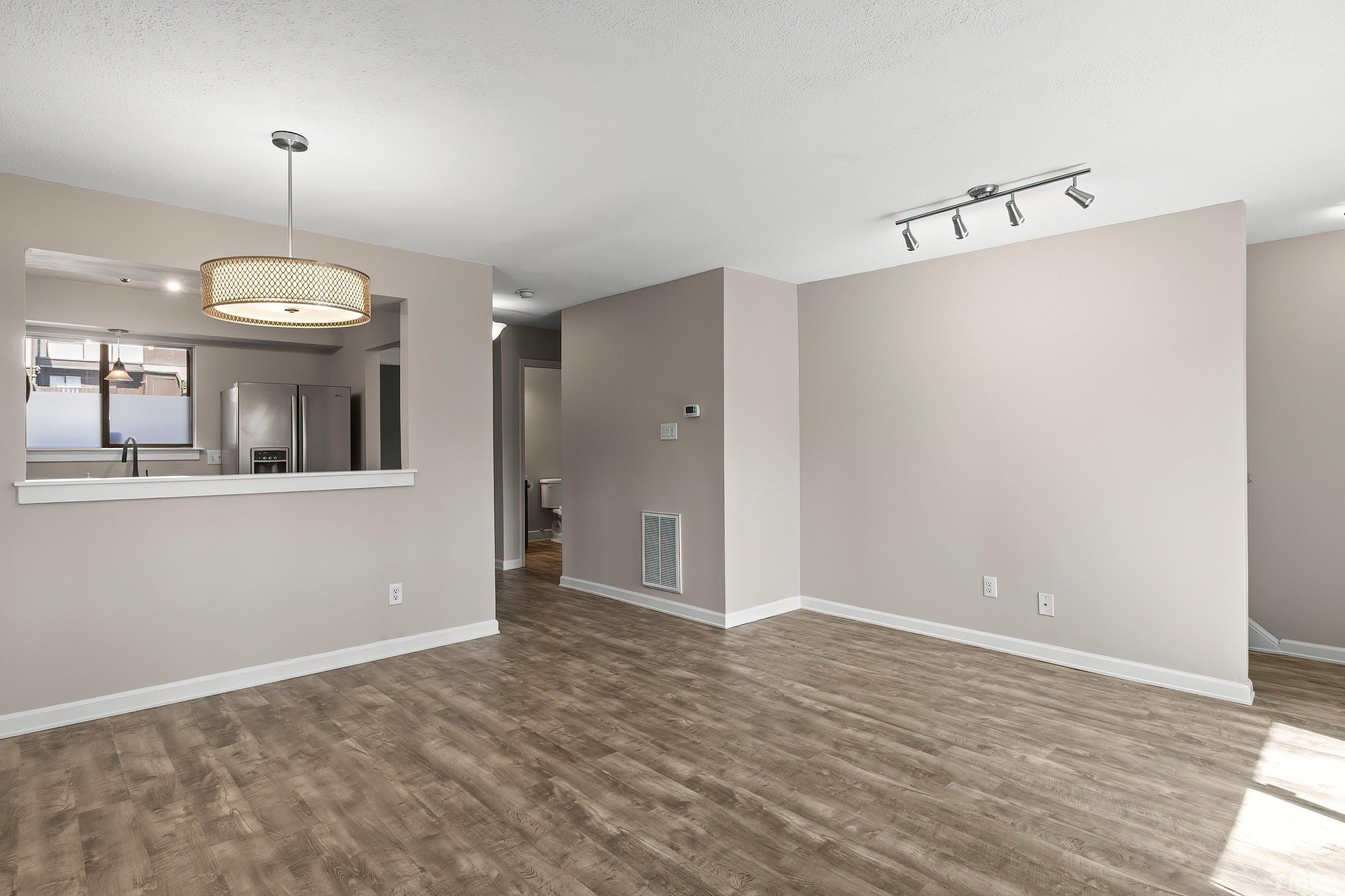4247 Lake Ridge Drive, Unit 4247 Raleigh, NC 27604 - Photo 11 of 26 an empty room with wooden floor mirror and windows