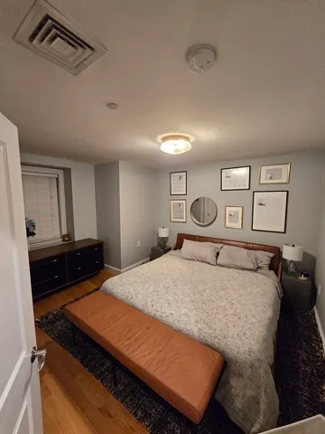 a bedroom with a bed and dresser with mirror
