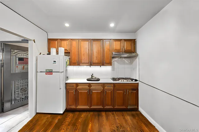 a kitchen with a refrigerator a sink and dishwasher with wooden floor