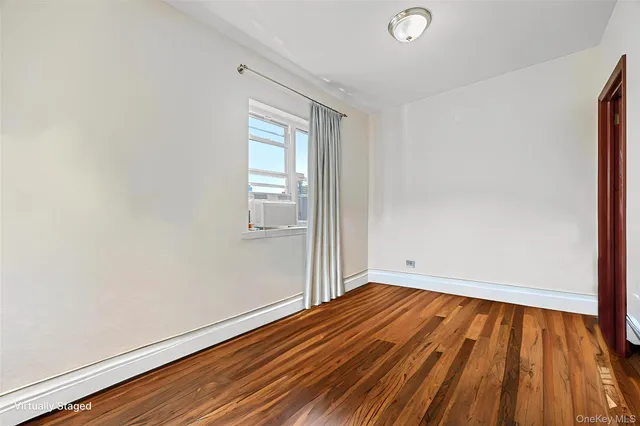 a view of a room with wooden floor and white walls