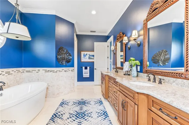 a bathroom with a granite countertop sink a mirror a vanity and a bathtub