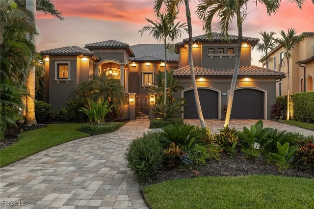 a front view of a house with a yard and potted plants