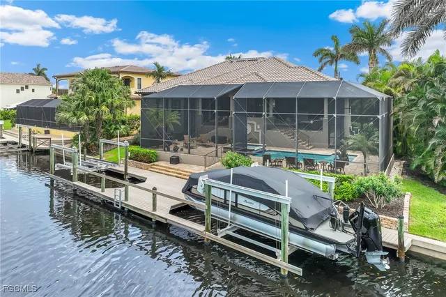 a view of house with outdoor space swimming pool and trees in the background