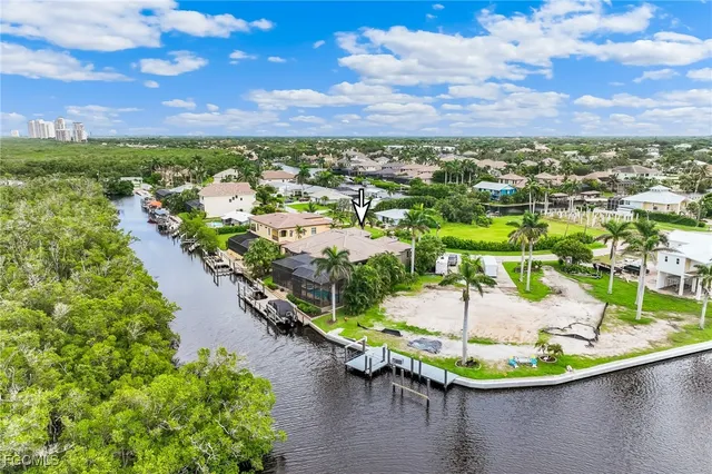 an aerial view of residential houses with outdoor space and lake view