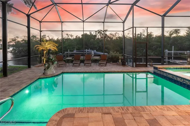 a view of a swimming pool with couches chairs and wooden fence