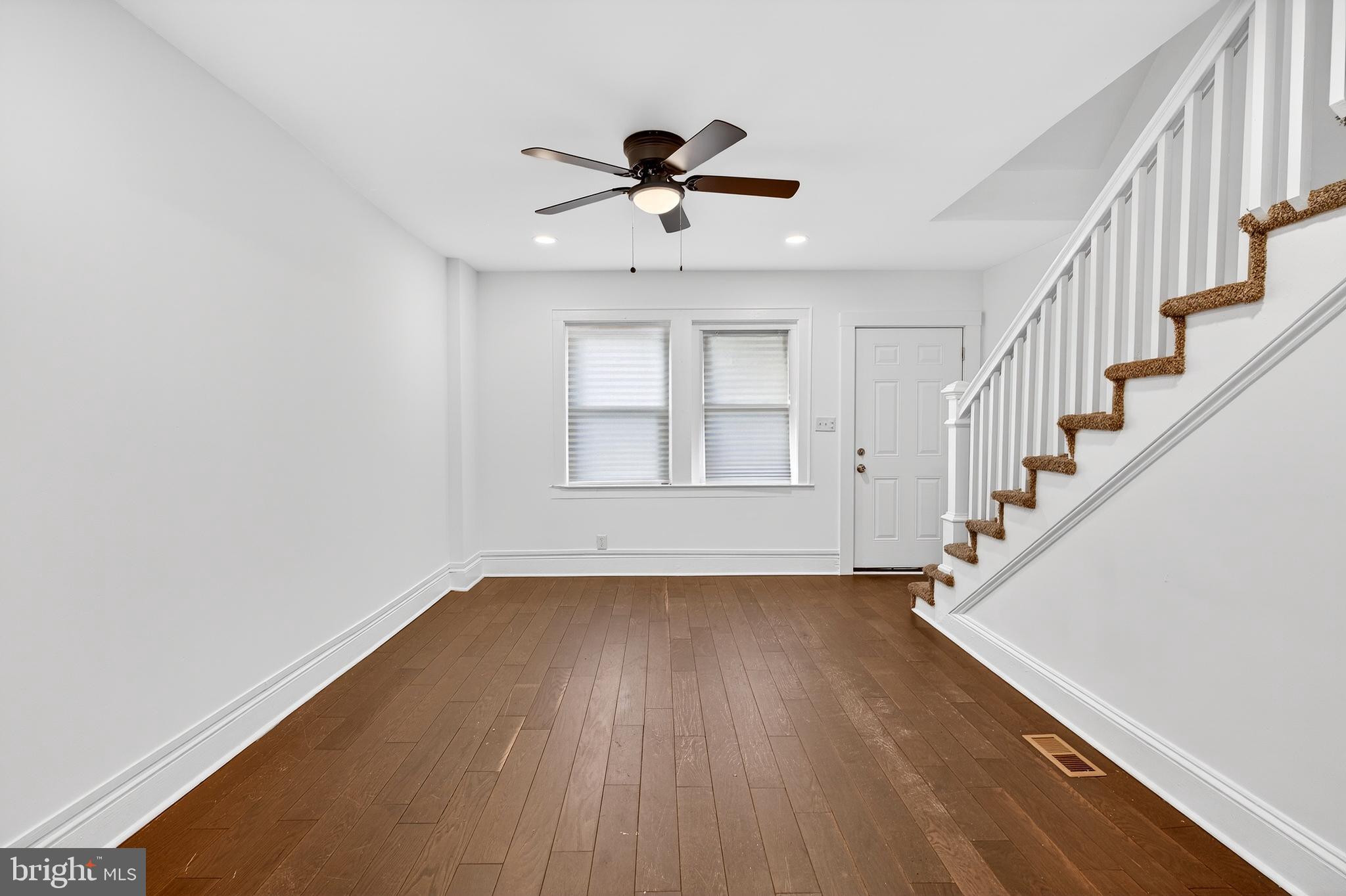 7014 Belclare Road Baltimore, MD 21222 - Photo 14 of 36 a view of empty room with wooden floor and ceiling fan