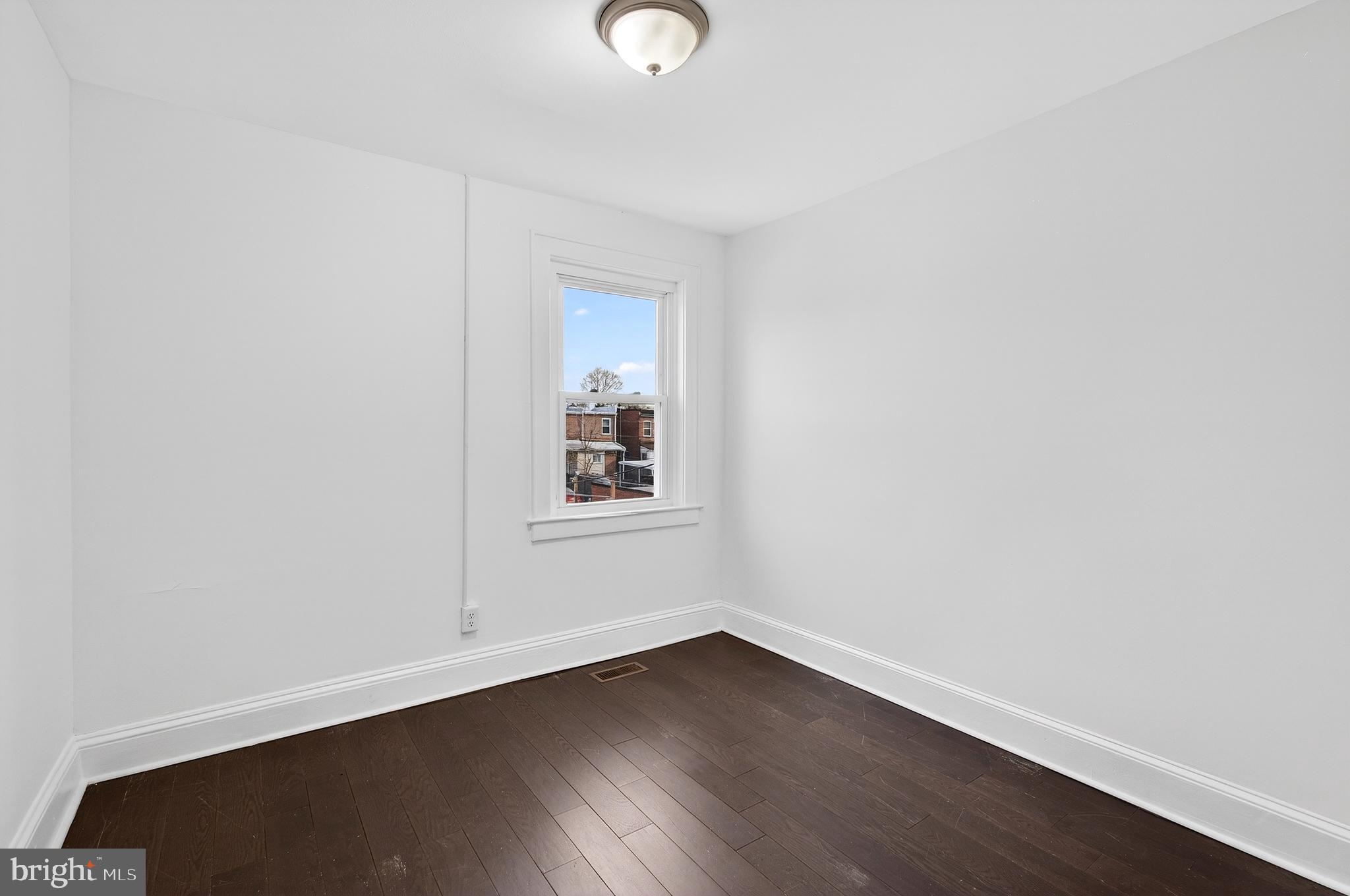 7014 Belclare Road Baltimore, MD 21222 - Photo 22 of 36 a view of an empty room with wooden floor and a window