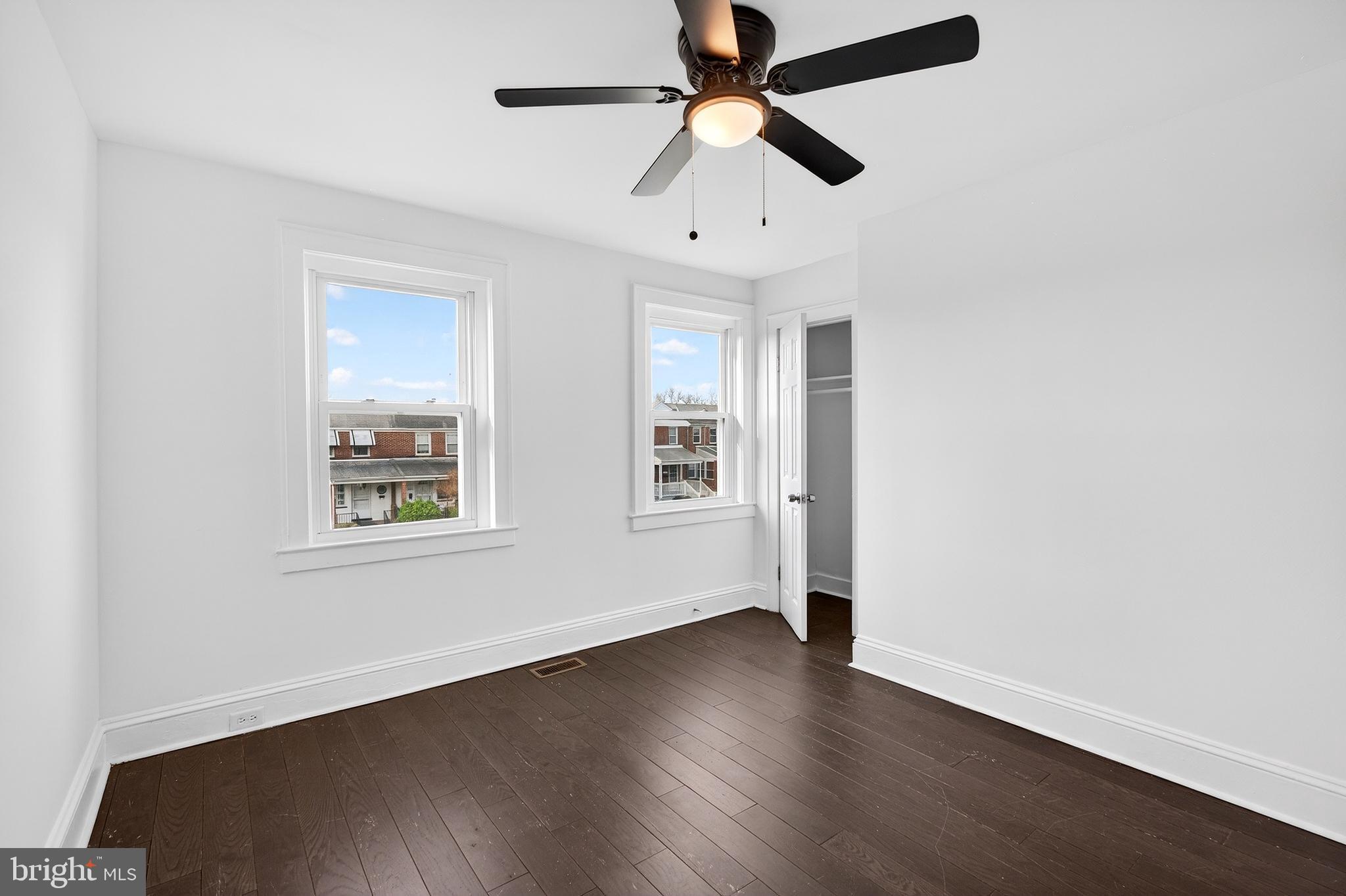 7014 Belclare Road Baltimore, MD 21222 - Photo 29 of 36 an empty room with wooden floor ceiling fan and windows