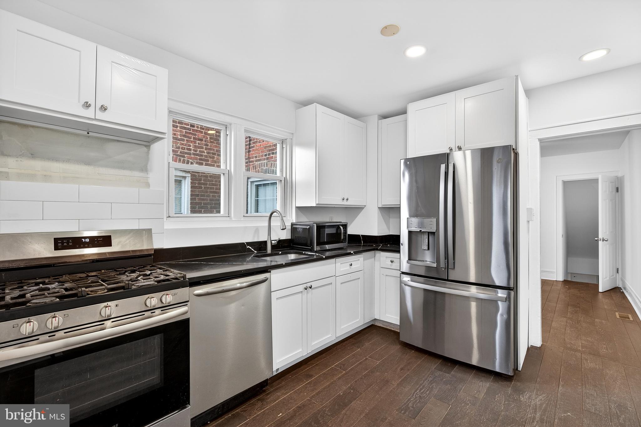 7014 Belclare Road Baltimore, MD 21222 - Photo 4 of 36 a kitchen with stainless steel appliances a refrigerator a sink a stove a microwave and cabinets