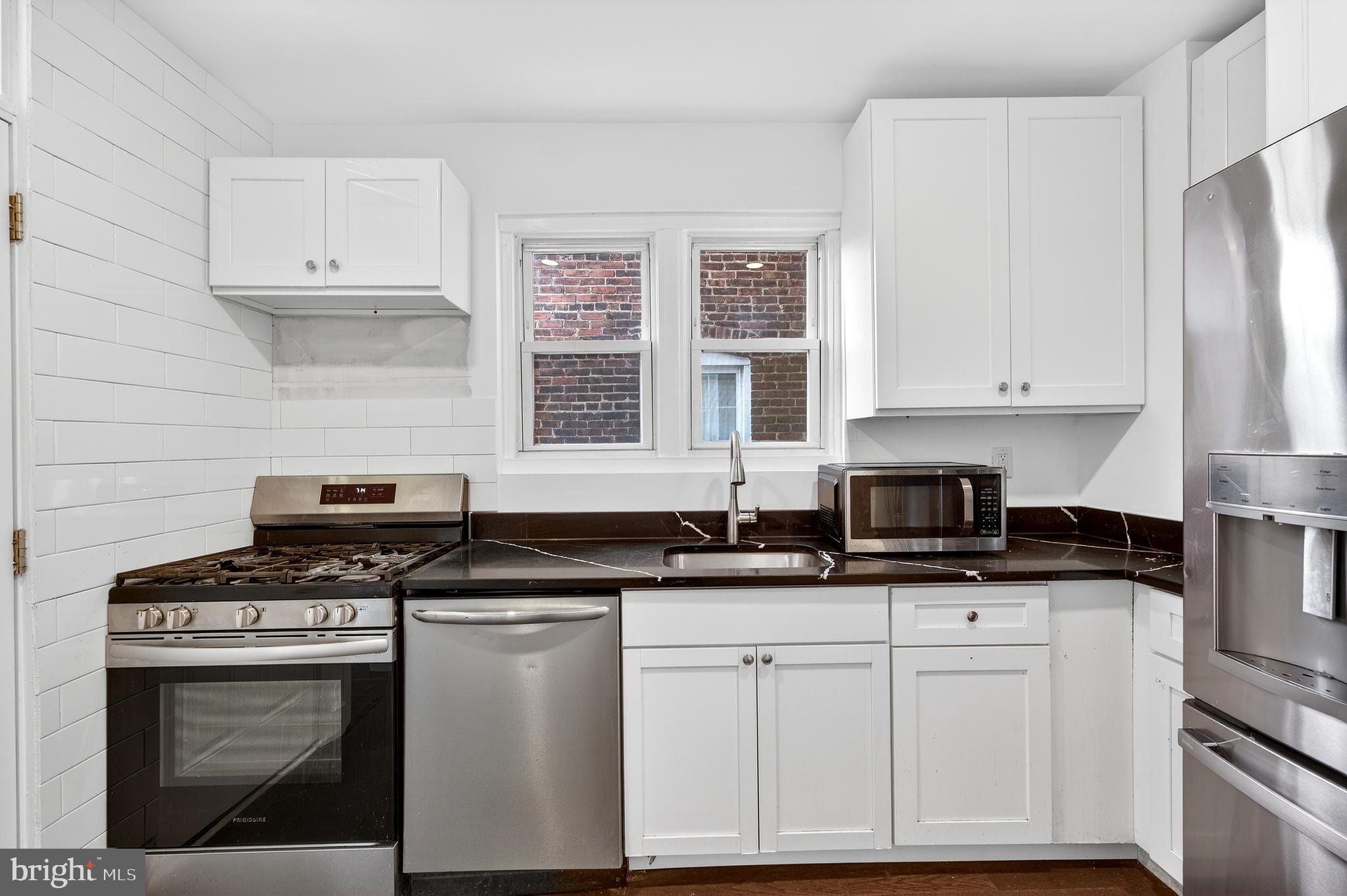 7014 Belclare Road Baltimore, MD 21222 - Photo 5 of 36 a kitchen with granite countertop a stove sink and cabinets