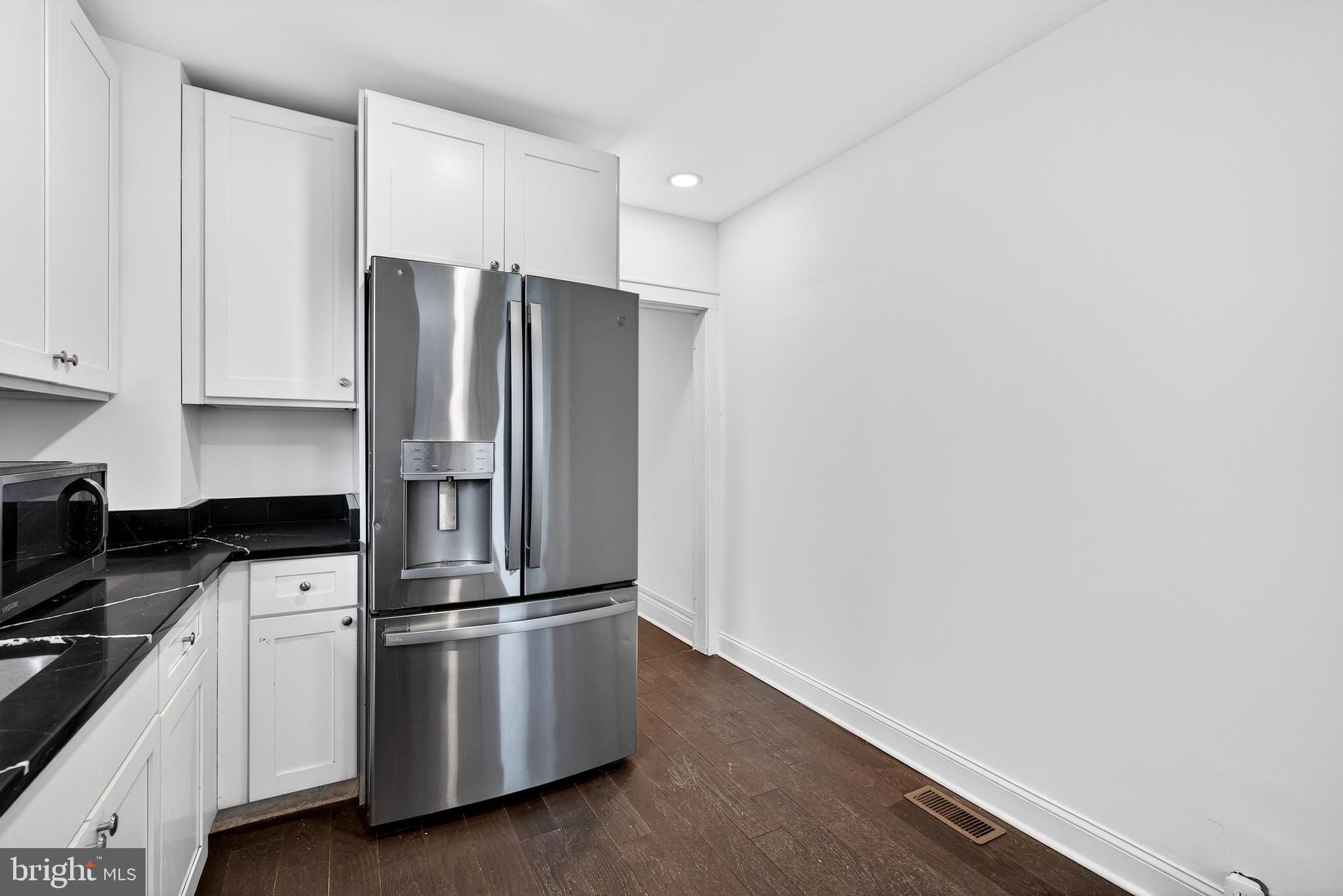 7014 Belclare Road Baltimore, MD 21222 - Photo 6 of 36 a kitchen with granite countertop white cabinets and stainless steel appliances