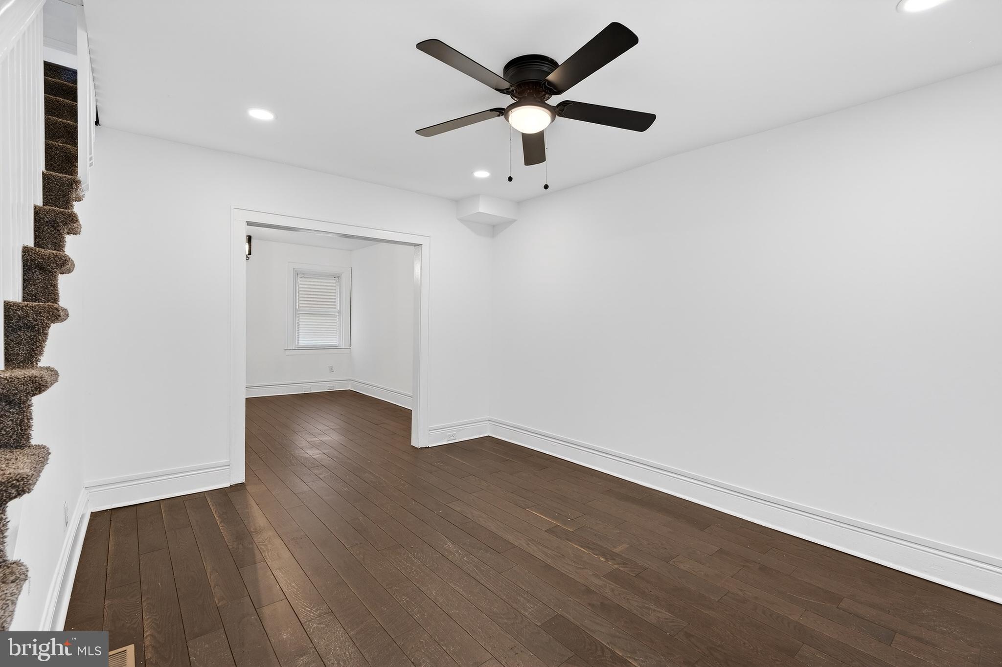 7014 Belclare Road Baltimore, MD 21222 - Photo 8 of 36 an empty room with wooden floor and ceiling fan